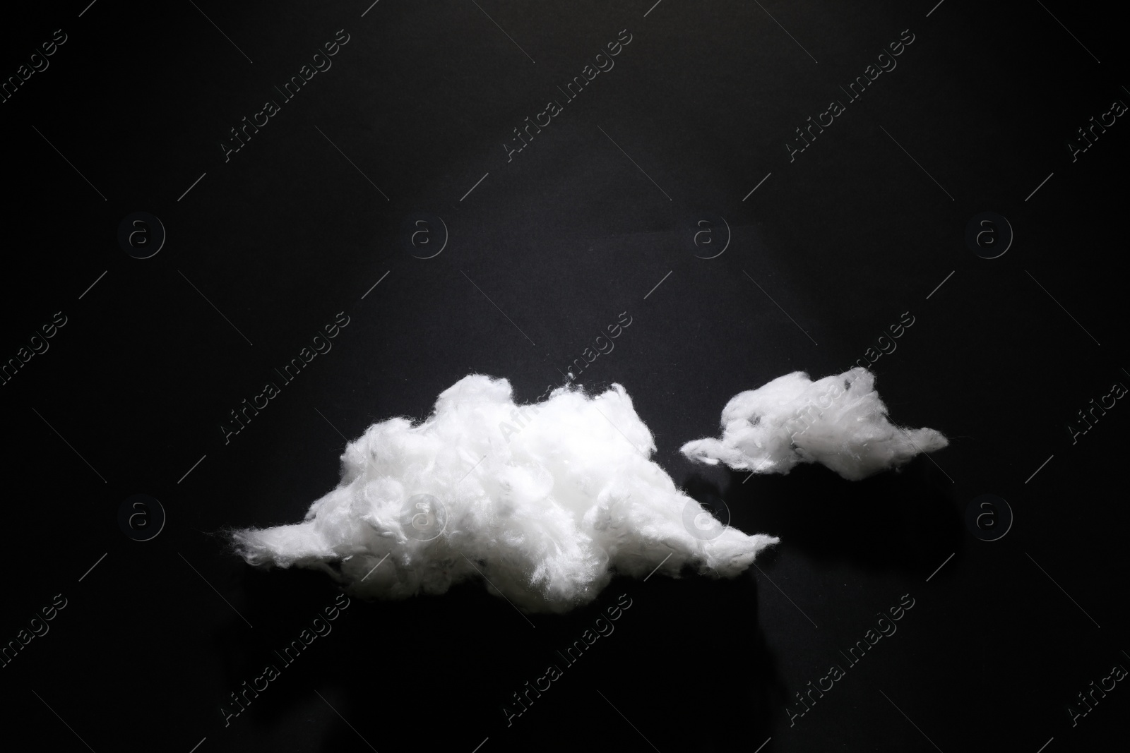 Photo of Clouds made of cotton on black background. Space for text