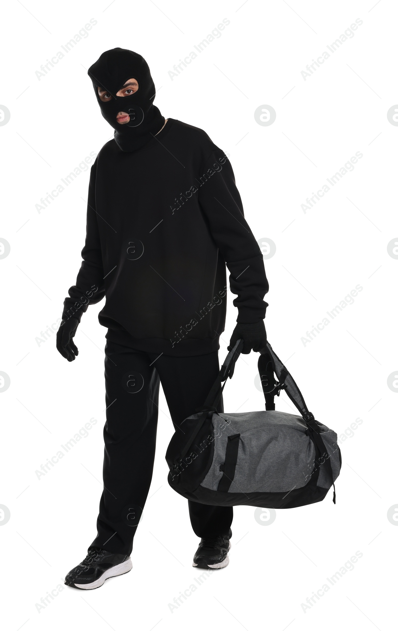 Photo of Thief in balaclava with bag on white background