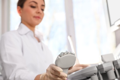 Photo of Sonographer holding ultrasound machine probe with gel in clinic