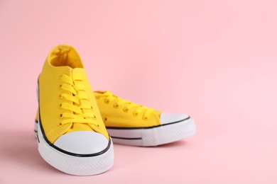 Photo of Pair of stylish sneakers on pink background, space for text