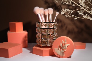 Photo of Stylish presentation of makeup brushes on white table
