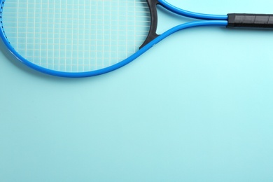 Tennis racket on light blue background, top view. Space for text