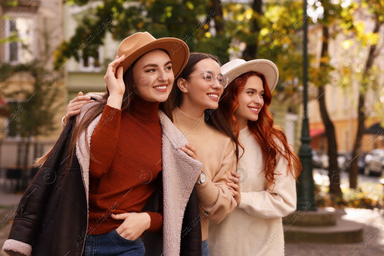 Photo of Portrait of happy friends posing outdoors on autumn day