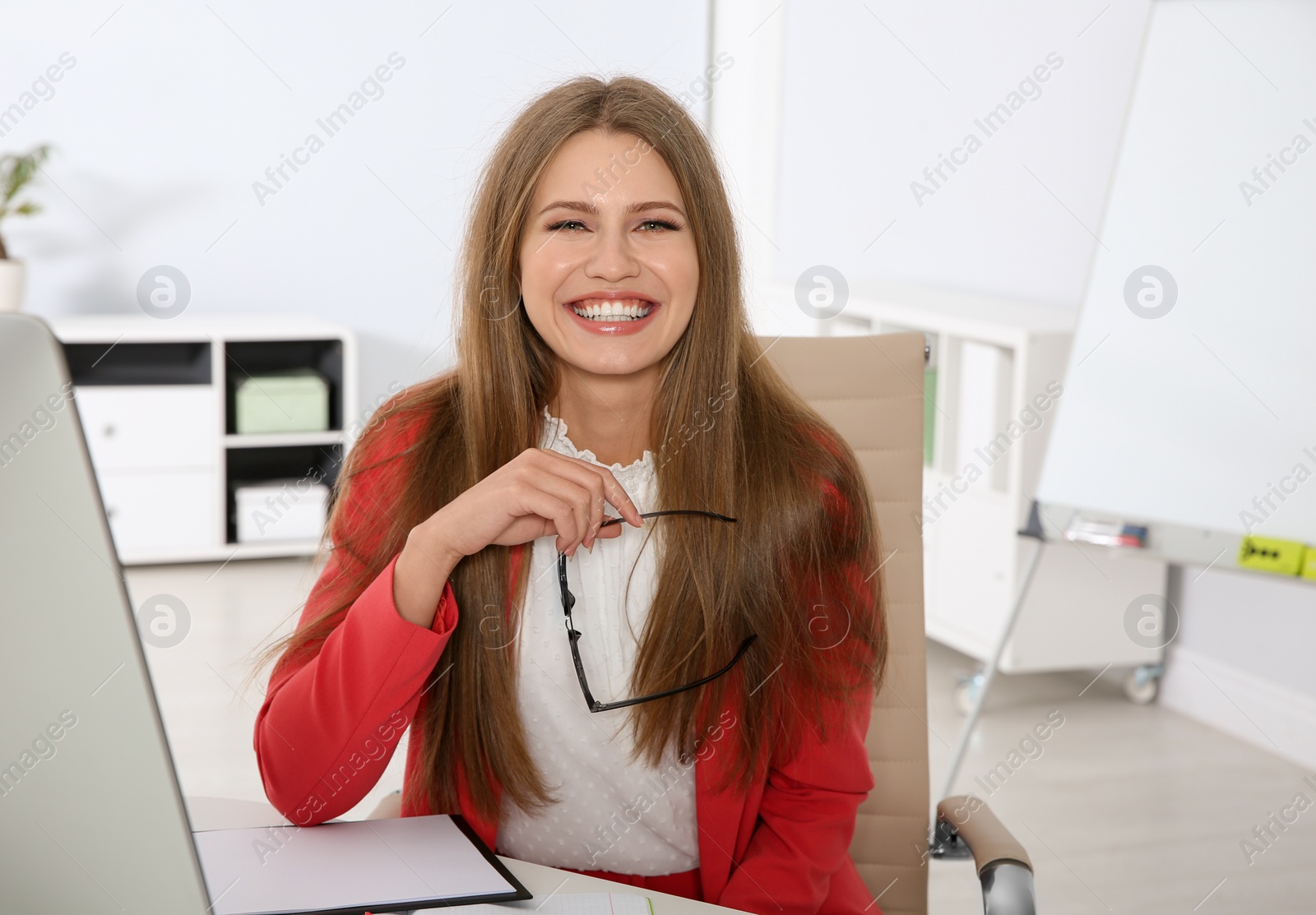 Photo of Portrait of young businesswoman laughing at workplace
