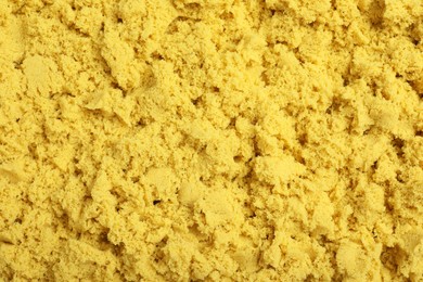 Photo of Yellow kinetic sand as background, closeup view