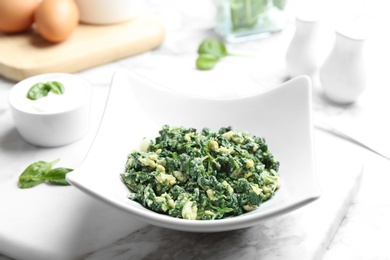 Plate with tasty cooked spinach on table. Healthy food