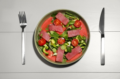 Photo of Tasty salad with red fish on light wooden table, flat lay