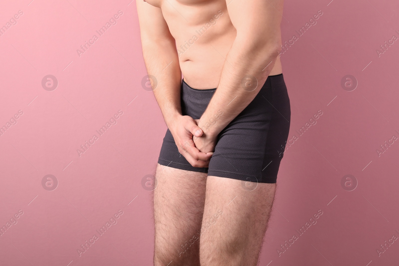 Photo of Young man with urological problems suffering from pain on color background