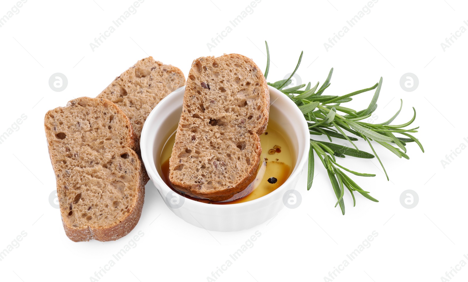 Photo of Bowl of organic balsamic vinegar with oil served with spices and bread slices isolated on white