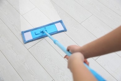 Image of Woman cleaning parquet floor with mop, closeup. Difference before and after cleaning