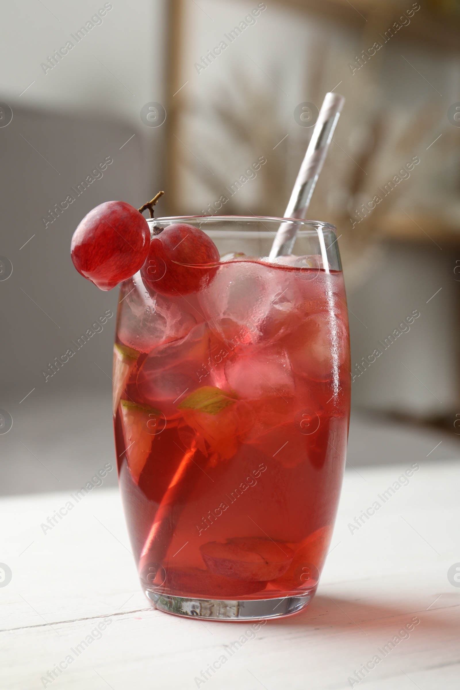 Photo of Grape soda water with ice and lime on white wooden table indoors. Refreshing drink