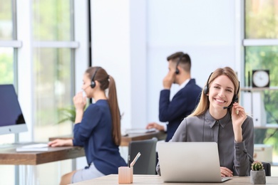 Photo of Female receptionist with headset at desk in office