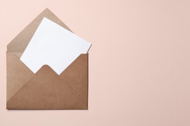 Photo of Letter envelope with card on beige background, top view. Space for text