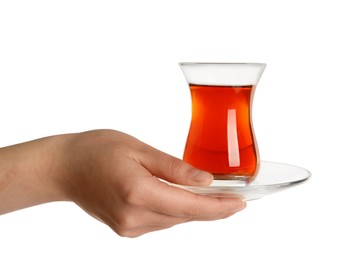 Woman holding glass of traditional Turkish tea with saucer on white background, closeup