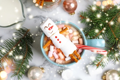 Image of Flat lay composition with marshmallow snowman in cup of hot drink on white marble table. Bokeh effect