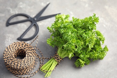 Photo of Rope and fresh green parsley on grey background