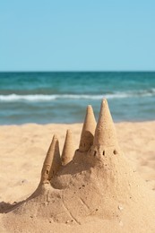 Photo of Beach with sand castle near sea on sunny day