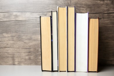 Collection of different books on white shelf, space for text