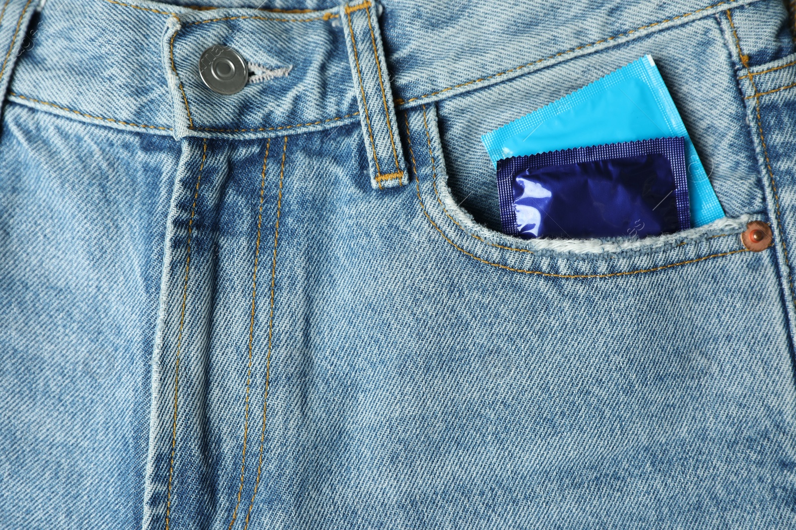 Photo of Packaged condoms in jeans pocket, closeup. Safe sex