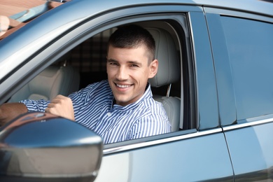 Photo of Attractive young man in modern luxury car