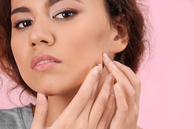 Beautiful young woman with acne problem on color background