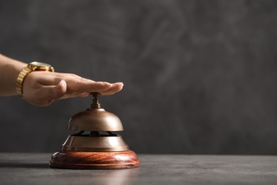 Photo of Woman ringing hotel service bell at table, closeup. Space for text