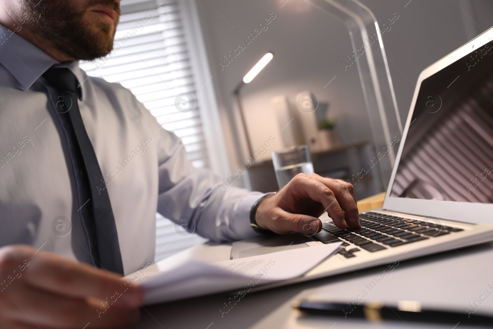 Photo of Businessman working with documents at wooden desk in office, closeup