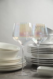 Set of clean dishes and glasses on light grey table