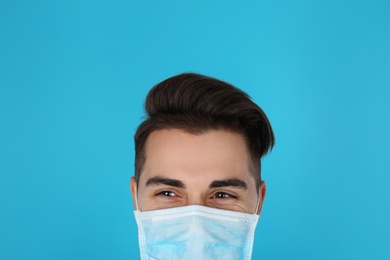 Photo of Young medical student with face mask on color background, closeup