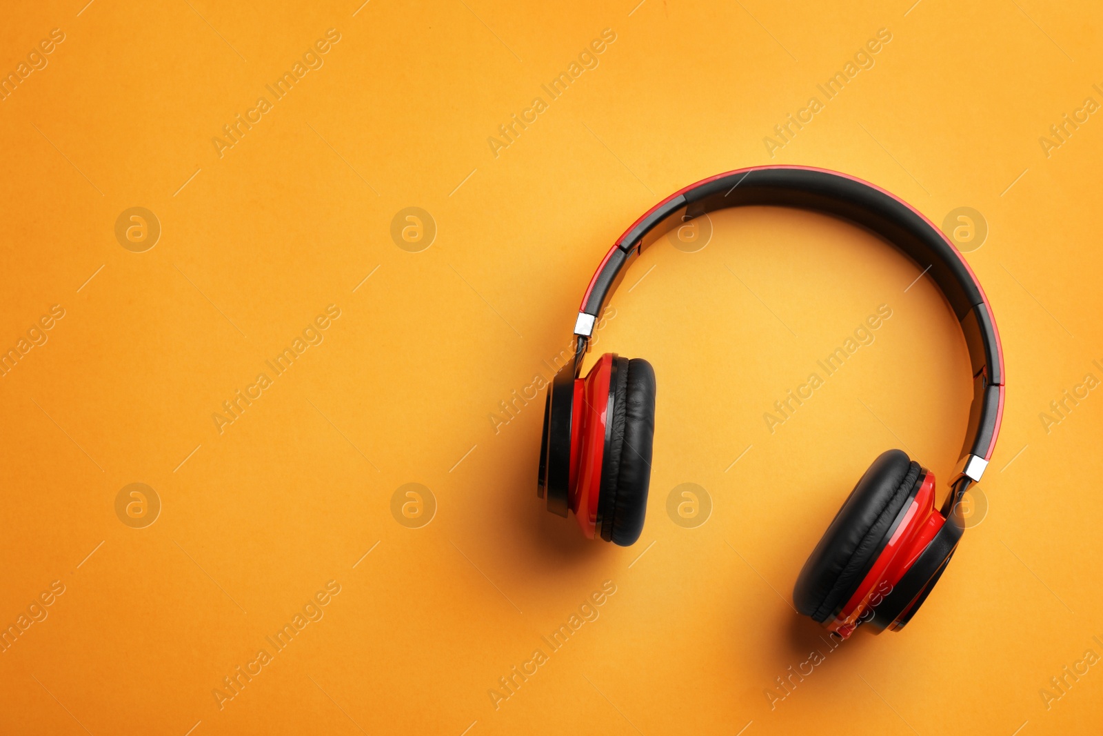 Photo of Wireless headphones on color background, top view. Space for text