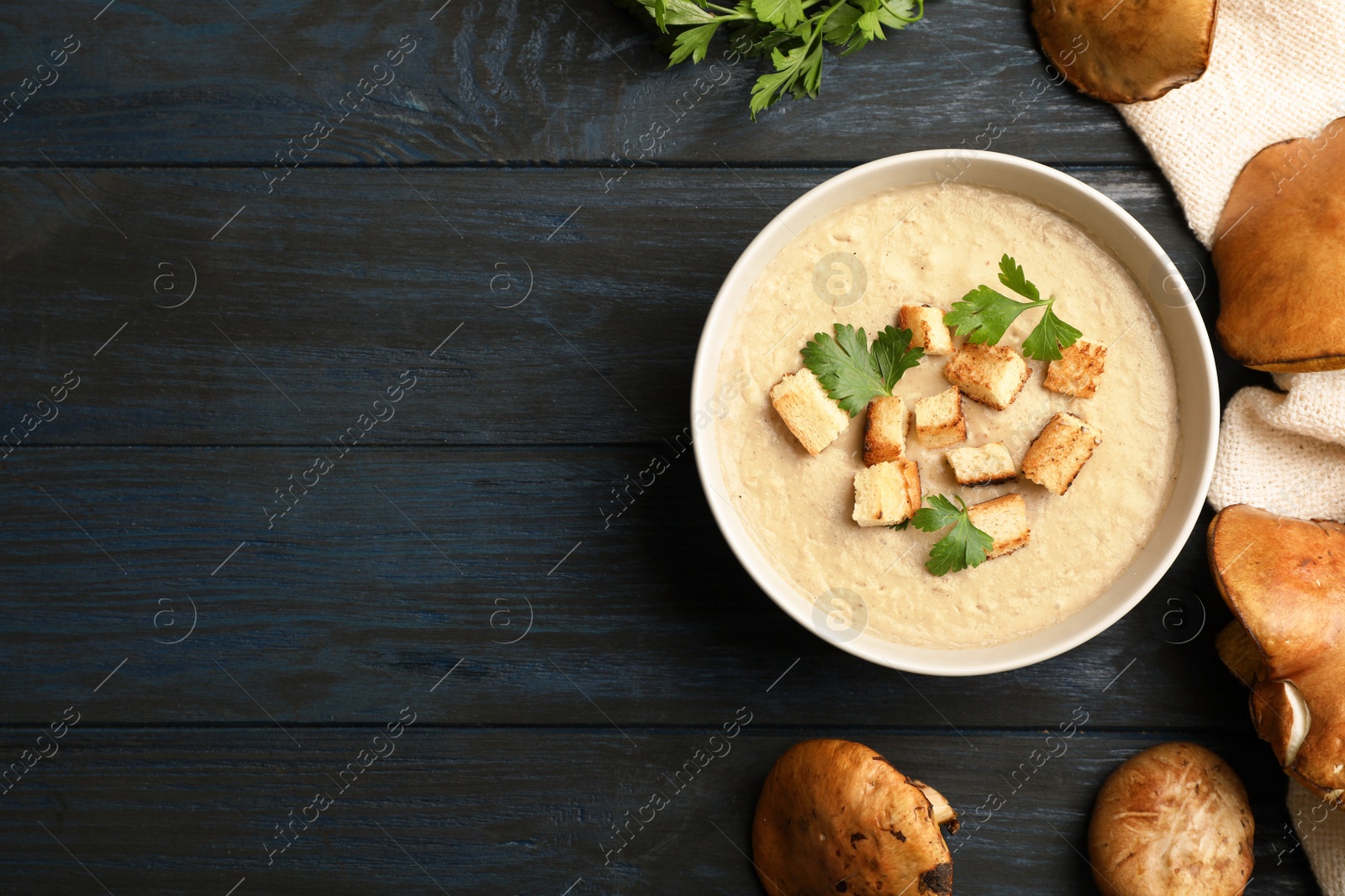 Photo of Flat lay composition with bowl of fresh homemade mushroom soup and space for text on wooden background