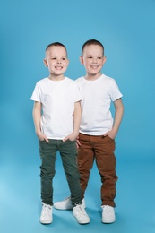 Photo of Full length portrait of cute twin brothers on color background