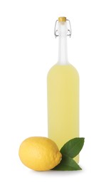 Photo of Bottle of tasty limoncello liqueur, lemon and green leaves isolated on white