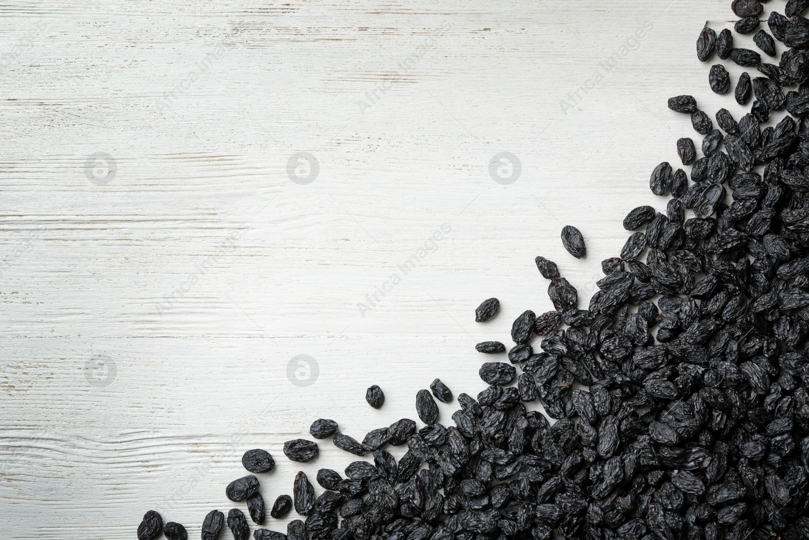 Photo of Raisins on wooden background, top view with space for text. Dried fruit as healthy snack