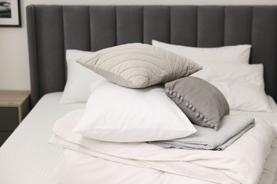Photo of Soft pillows and bedding set on bed at home