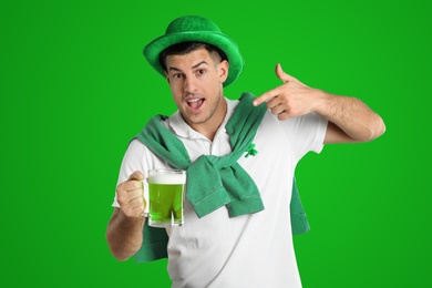 Image of Man in St. Patrick's Day outfit with beer on green background