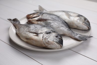 Fresh raw dorado fish on white wooden table, closeup