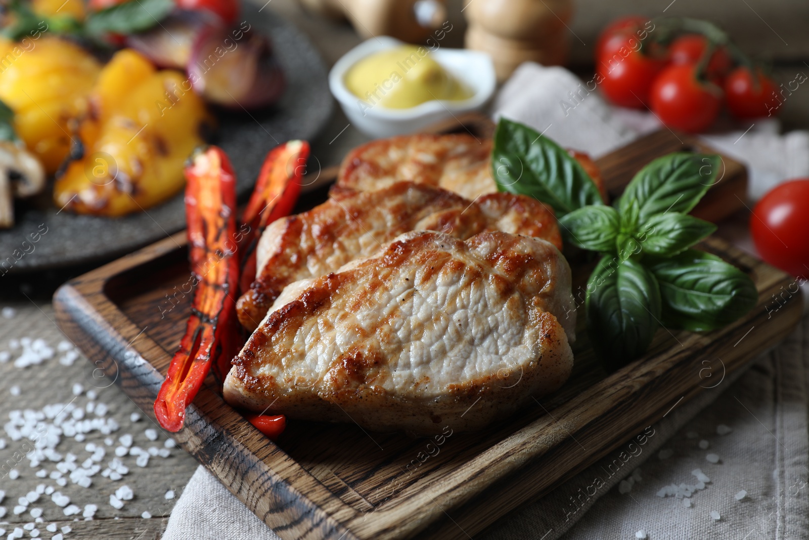 Photo of Delicious grilled meat and vegetables served on wooden table, closeup