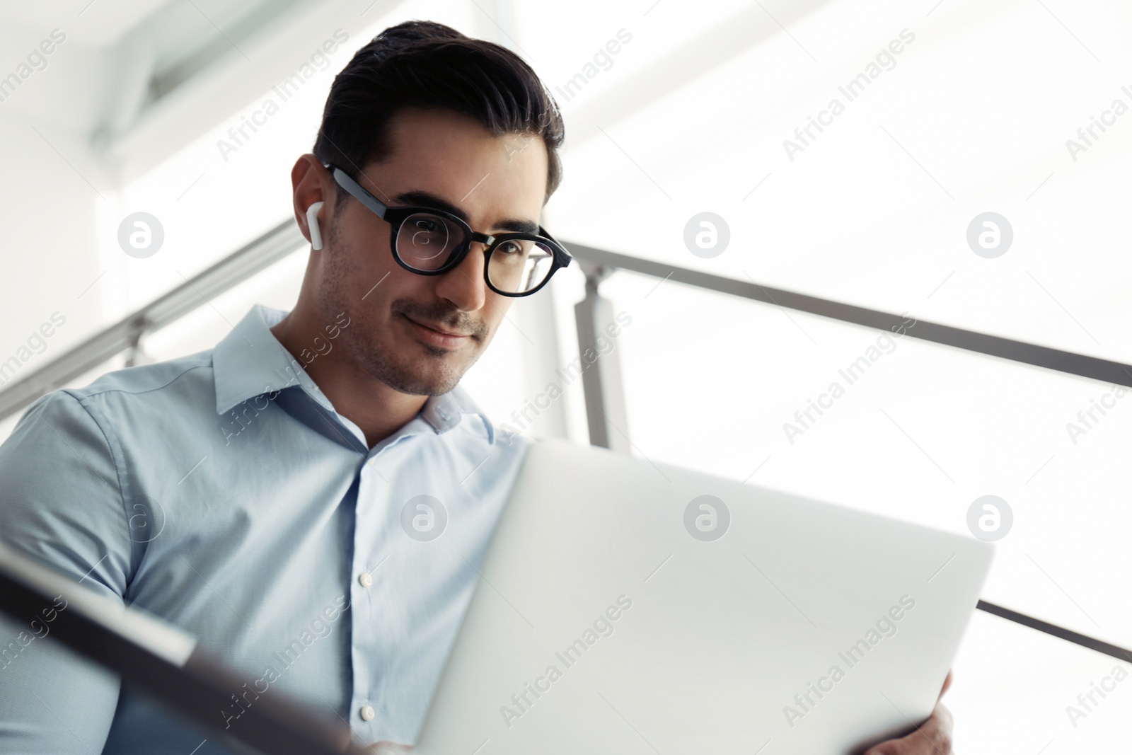 Photo of Portrait of young man with laptop indoors