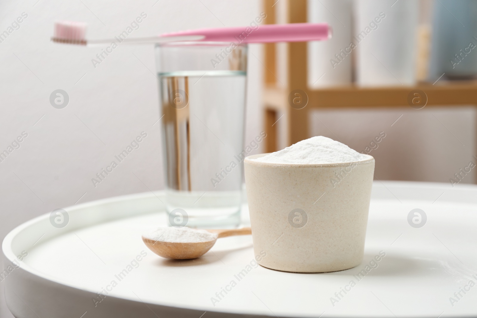 Photo of Bowl and spoon with baking soda on table indoors