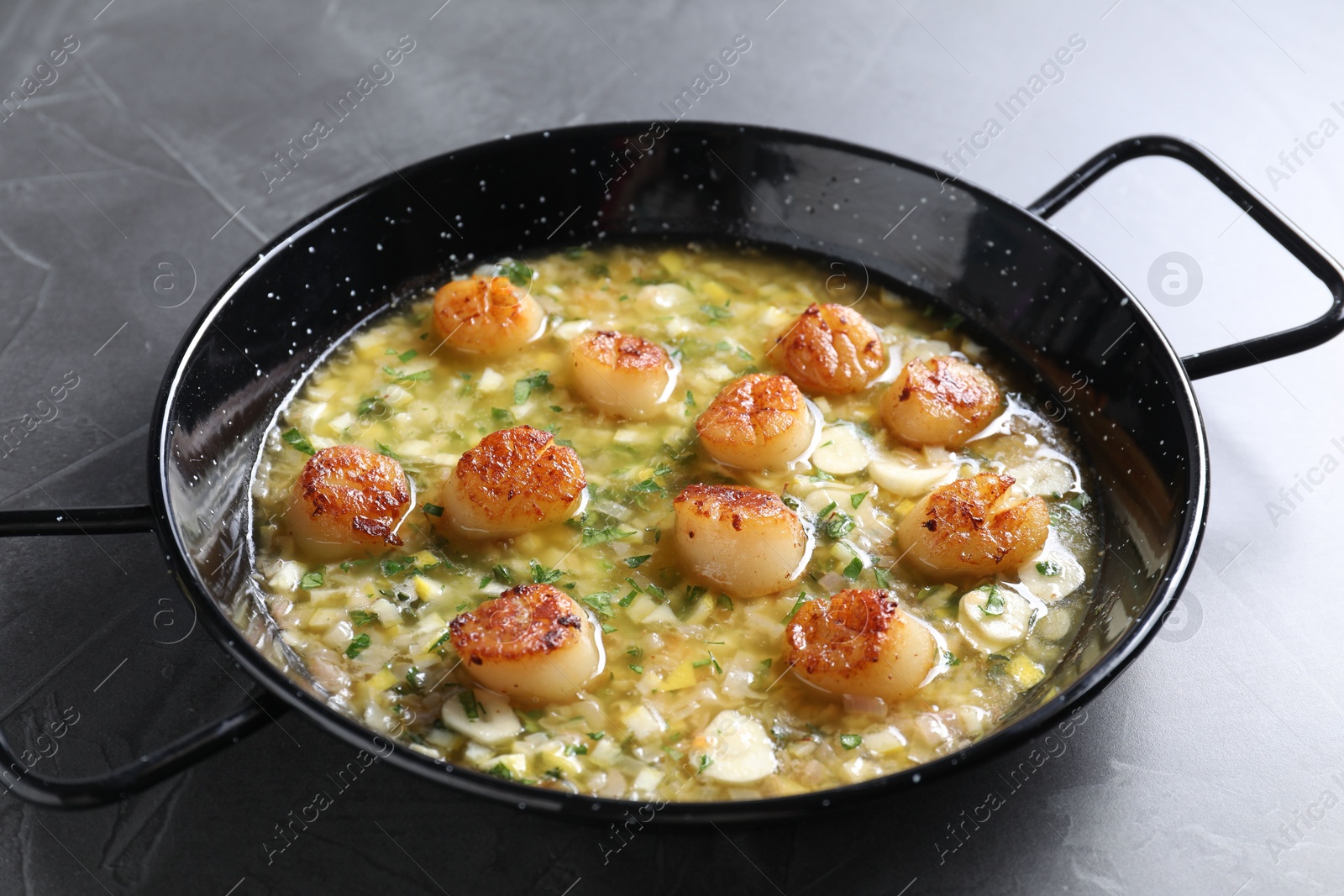 Photo of Fried scallops with sauce in dish on grey table, closeup