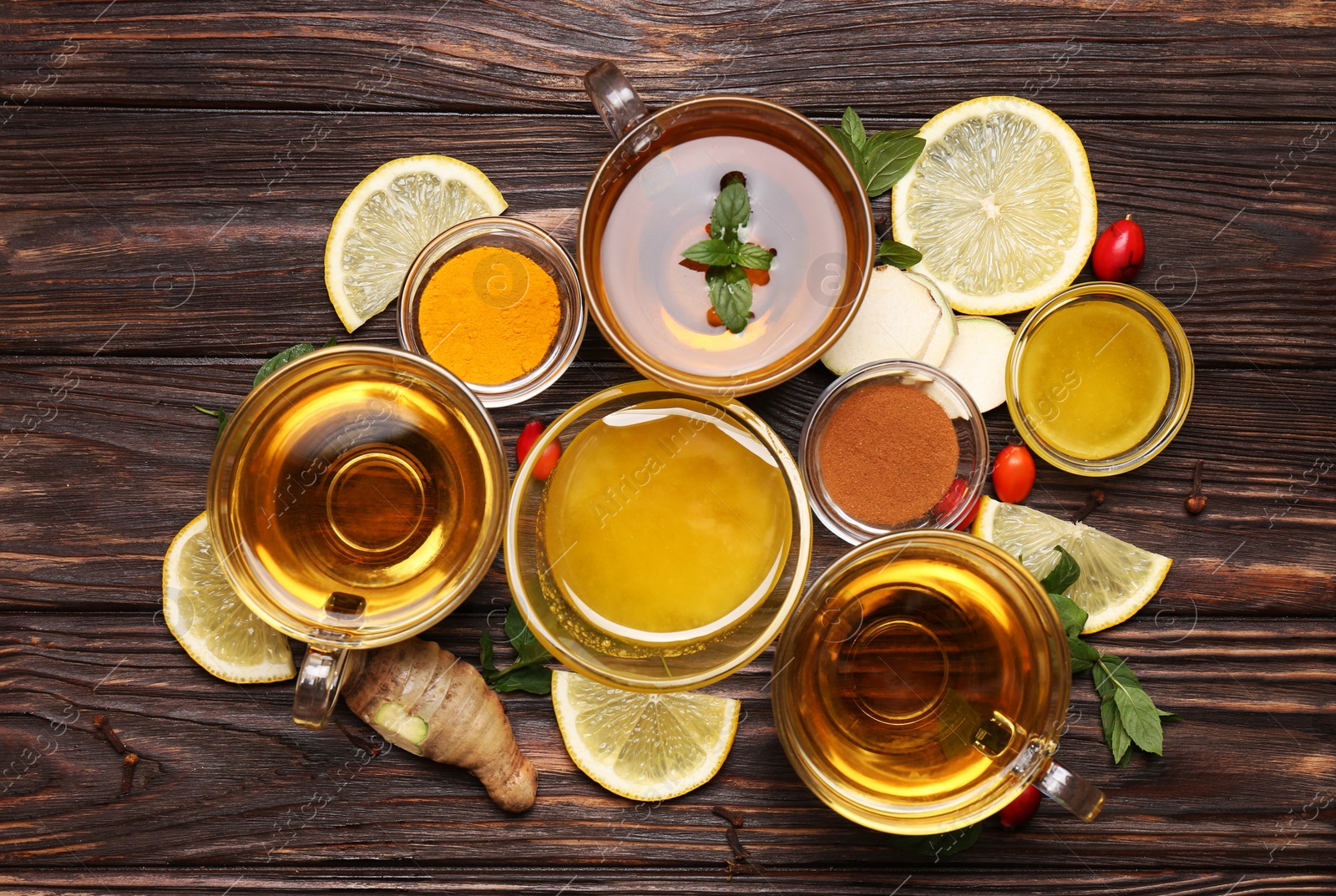 Photo of Flat lay composition of tea with honey and ingredients on wooden table