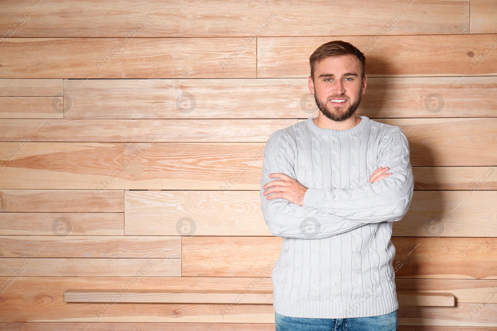 Image of Handsome man wearing warm sweater on wooden background. Space for text