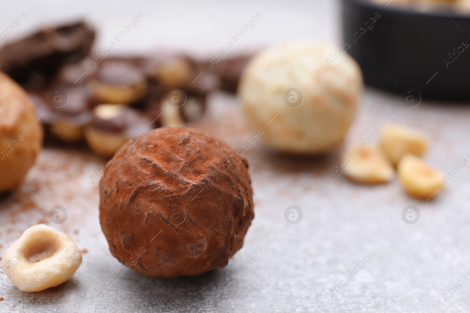 Photo of Tasty chocolate candy on light grey table, closeup. Space for text