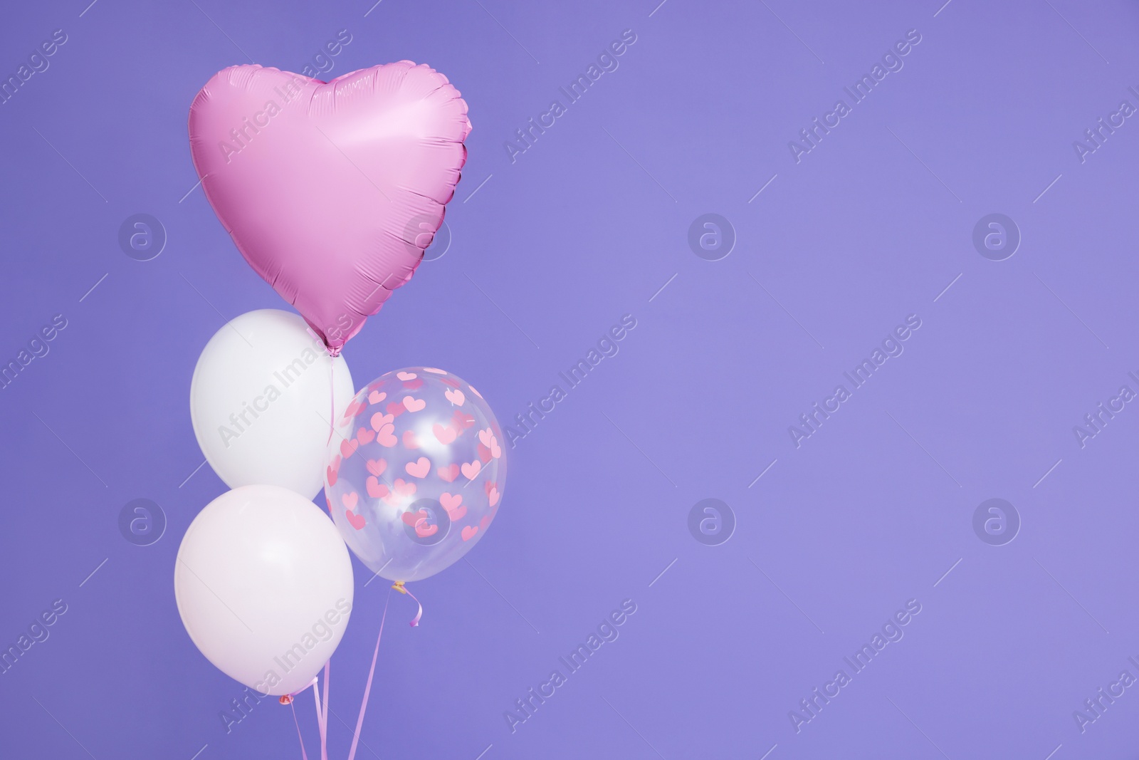 Photo of Bunch of heart and round shaped balloons on violet background, space for text. Birthday party