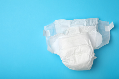 Photo of Baby diaper on light blue background, top view. Space for text
