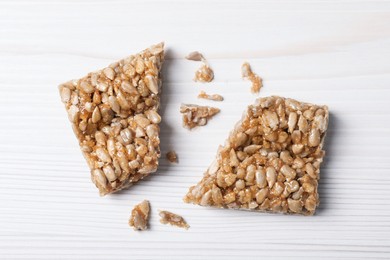 Photo of Delicious sweet kozinaki pieces on white wooden table, flat lay