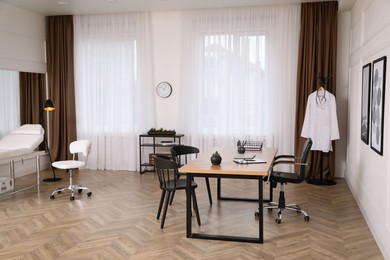 Modern medical office interior with doctor's workplace and chairs