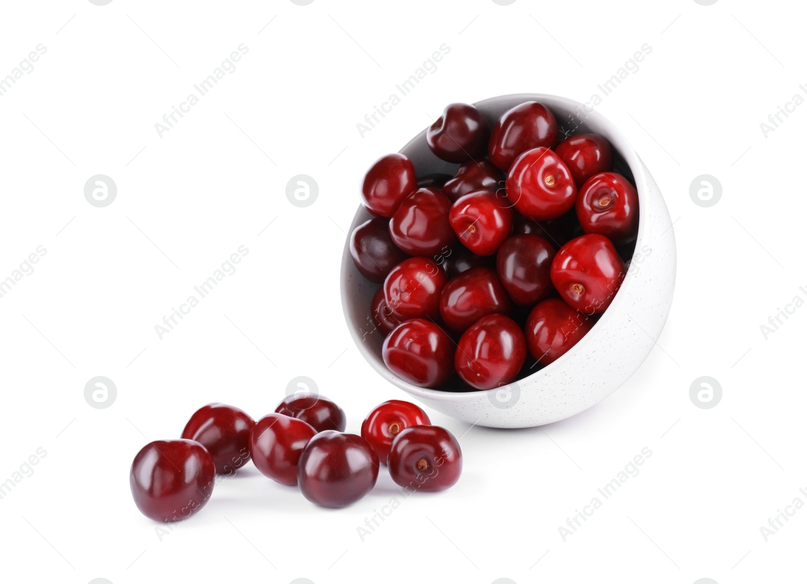 Photo of Tasty scattered red cherries and bowl isolated on white