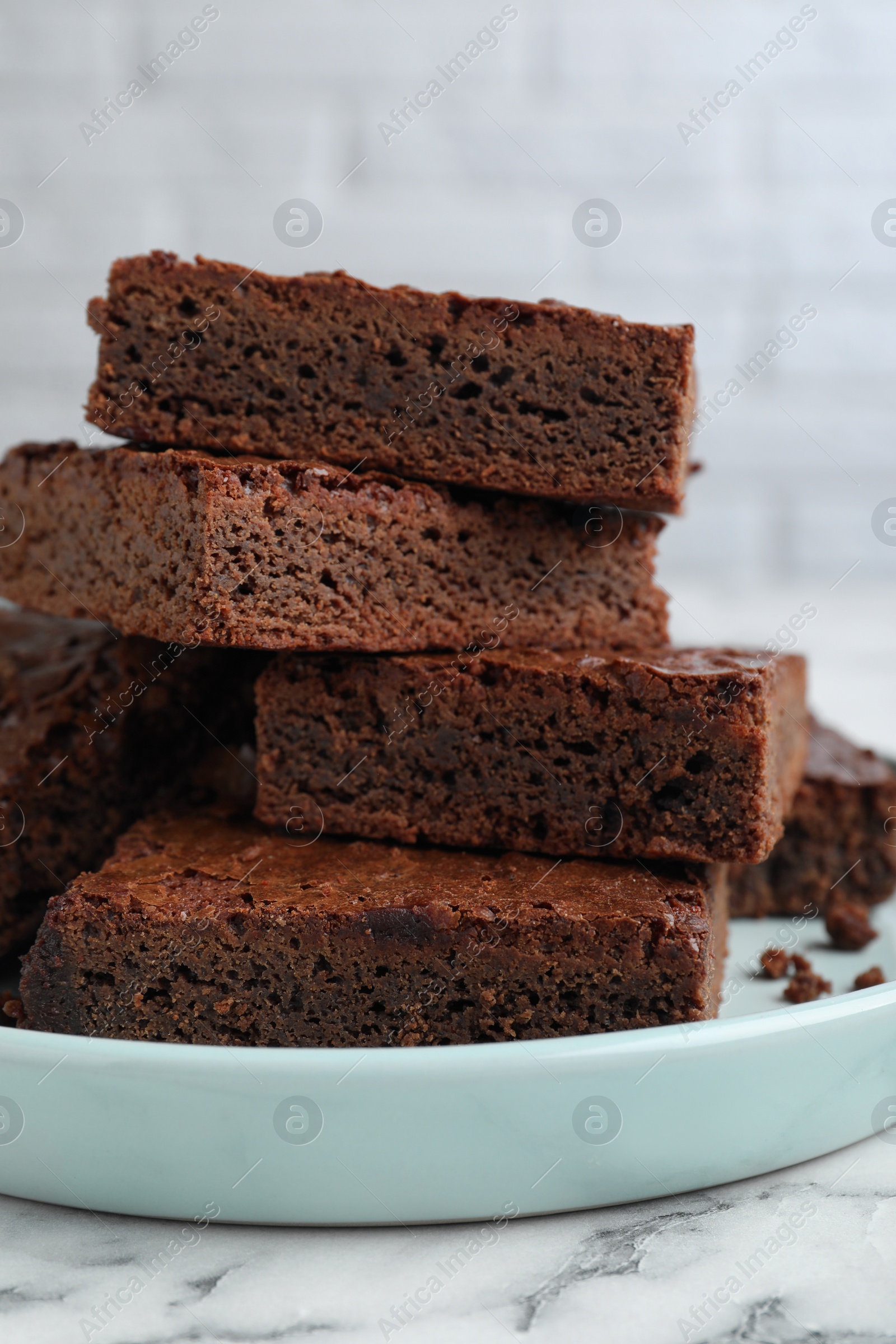 Photo of Delicious chocolate brownies on white marble table, closeup